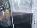 Interior view of a 2016 Ford Transit showing an open door with a handle and a fire extinguisher mounted on the wall