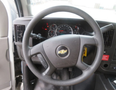 Steering wheel and dashboard of a 2020 Chevrolet Express featuring gauges and controls