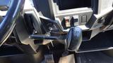 An interior view of a 2016 Polaris Ranger 570 Crew showing the gear shift lever and dashboard controls