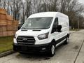 A white 2020 Ford Transit van with a black front grille parked on a street