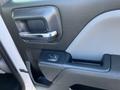 Interior door panel of a 2018 GMC Sierra 1500 featuring a chrome door handle and a power window control button