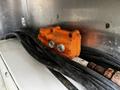 An orange control box with two knobs and multiple black cables connected to it