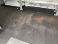 The interior flooring of a 2018 Ford Transit van showing a flat surface with some discoloration and a diamond plate section