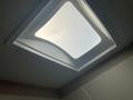A skylight with a square frame and slightly curved edges, allowing diffused light to enter a camper's interior ceiling