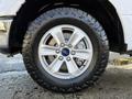 A close-up of a silver alloy wheel and tire from a 2018 Ford F-150 showcasing the Ford logo on the center cap and rugged tread pattern on the tire