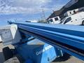 A blue 1997 Genie S-65 4X4 aerial work platform featuring a long extendable boom and a control box mounted on the side