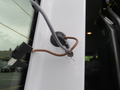 A 2009 Dodge Sprinter Van with a gray cable connected to a black mounting point on the side