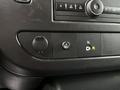 Close-up of the control panel in a 2023 GMC Savana showing various buttons and knobs for audio and vehicle settings