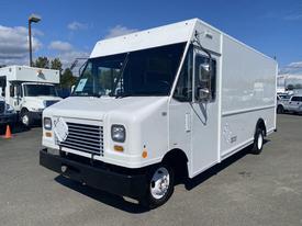 A white 2012 Ford Econoline delivery vehicle with a boxy shape and a large windshield parked in a lot