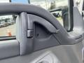 Close-up of the interior door handle on a 2008 Mitsubishi Fuso FE180 showing a gray plastic design and mounting screw