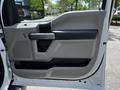 A close-up view of the driver's side door panel of a 2020 Ford F-350 Super Duty featuring gray plastic accents and a handle