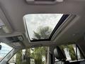 Interior view of a 2021 Toyota 4Runner showcasing a panoramic sunroof with a glimpse of palm trees visible through the glass