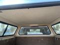 Interior view of a truck bed with a cap featuring a textured ceiling and side windows showing a glimpse of the truck's rear interior