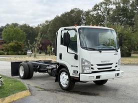 A white 2017 Isuzu NPR HD truck with a bare chassis and no cargo container is parked on a street with a clear view of the front and side