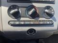 Dashboard controls of a 2013 Ford Expedition featuring knobs for climate control and air conditioning with indicator lights