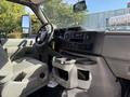 Interior of a 2021 Ford Econoline with gray seats a dashboard featuring a radio controls and cup holders
