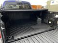 A 2022 Toyota Tacoma with an open truck bed featuring a black rubber liner and organizational features for cargo storage