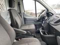 Interior of a 2018 Ford Transit showcasing two front seats and the dashboard with controls and storage compartments