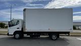 A 2018 Mitsubishi Fuso FE box truck with a large white cargo area and a cab visible on the left side