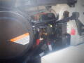 A close-up view of the engine compartment of a 2016 International WorkStar 7500 showing various wires components and a warning label