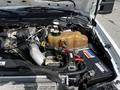 Engine compartment of a 2008 Ford F-550 featuring the turbocharger intake piping battery and coolant reservoir with various hoses and cables visible