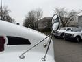 A 2017 Kenworth T370 truck with a shiny side mirror reflecting its surroundings and a prominent logo on the front grille