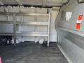 Interior of a 2014 Chevrolet Express with metal shelving units and a black floor devoid of cargo or other items