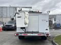 A 2017 Ford Econoline with an attached Versalift bucket lift on the back and a compartment for storage