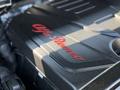 Close-up of the engine cover of a 2020 Alfa Romeo Stelvio featuring the Alfa Romeo logo in red against a black background