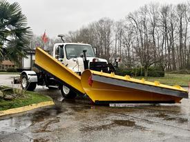 A 2016 Freightliner 108SD equipped with a large yellow snow plow mounted on the front