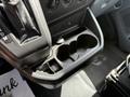 A close-up view of the center console of a 2016 Ford Transit featuring a gear shifter and a two-cup holder compartment