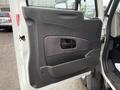 The interior door panel of a 2014 International TerraStar featuring a textured black surface with a patterned insert and a rounded door handle