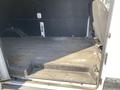 Interior view of a 2022 Ford Transit cargo van showing an empty loading area with a gray floor and a black driver's seat on the right