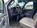 Interior view of a 2023 GMC Savana featuring a driver's seat and dashboard with controls and a steering wheel