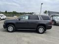 A 2016 Chevrolet Tahoe in dark gray color with chrome wheels and a sleek design parked on a lot