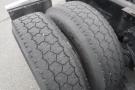 Close-up of two worn tires from a 2015 Kenworth T660 showing distinct tread patterns and wear levels