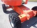 A 2008 JLG Boom Lift with large rubber tires and a distinctive orange body featuring directional arrow markings on its chassis
