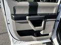 Interior door panel of a 2021 Ford F-550 featuring a sleek gray design with a handle and adjustable controls