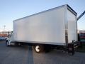 A 2014 International Durastar truck with a large empty white box cargo area and black chassis parked on a flat surface