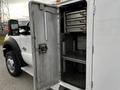 A 2016 Ford F-550 with an open door revealing internal storage compartments and shelves inside the truck's cargo area