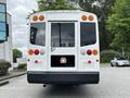 A 2015 Spartan School Bus viewed from the rear with multiple rear lights and a license plate featuring a lion logo