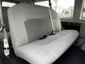 A gray upholstered bench seat from a 2014 Ford Econoline with seatbelts attached and a simple design