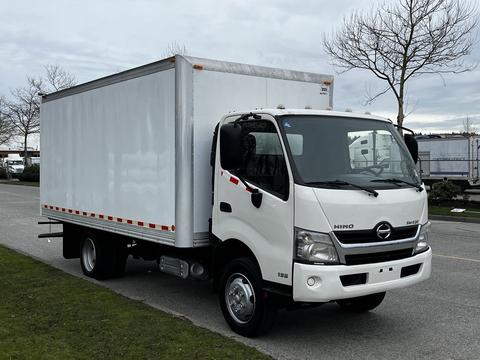 A white 2013 Hino 195 box truck with a large cargo area and visible side mirrors parked on a street