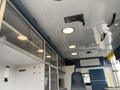 Interior view of a 2014 Chevrolet Express van showing overhead lights and a cabinet area with a driver's seat visible