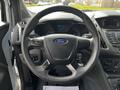 Steering wheel of a 2016 Ford Transit Connect with the Ford logo in the center and various controls on the wheel and dashboard