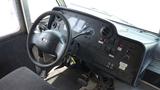 The interior of a 2011 Ford Econoline featuring the steering wheel dashboard controls and gear shift with various buttons and switches