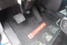 Close-up view of the foot pedals and floor mat inside a 2015 Kenworth T660 with the Kenworth logo visible on the mat