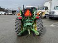 A 2003 John Deere 790 tractor viewed from the rear showing large tires and a green chassis with an orange safety triangle attached