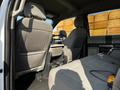 Interior view of a 2021 Ford F-550 showing the front seats and back seat area with gray fabric upholstery