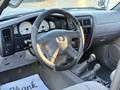 Interior view of a 2004 Toyota Tacoma showing the steering wheel dashboard and gear shift with gauges and controls in focus